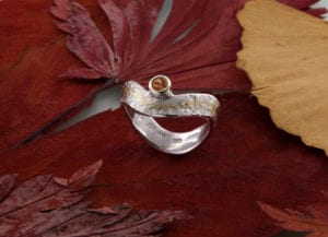Geschwungener Eisschlagring mit Mandaringranat seitlich Gold und Silber